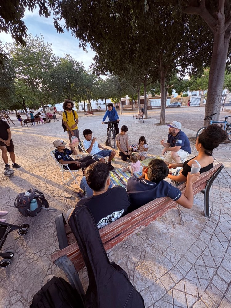 Familias, niños y miembros del equipo reunidos en una plaza del barrio
