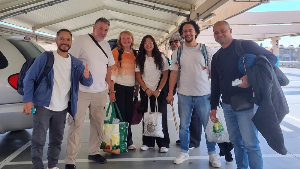 Un equipo sonriente con mochilas y bolsas listo para viajar